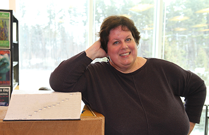 WCC instructor Betsy Foss leans against the unabridged Webster’s Third New International Dictionary in the college’s Writing Center.