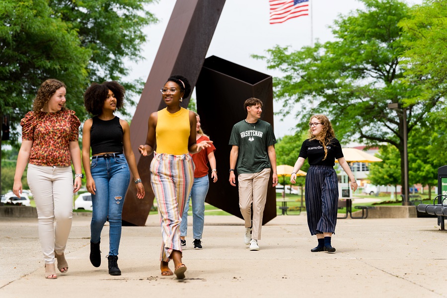 students in front of sculpture