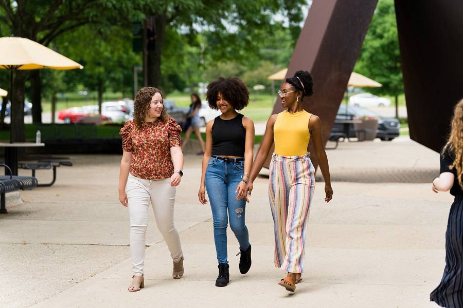 Three female students walk on campus.